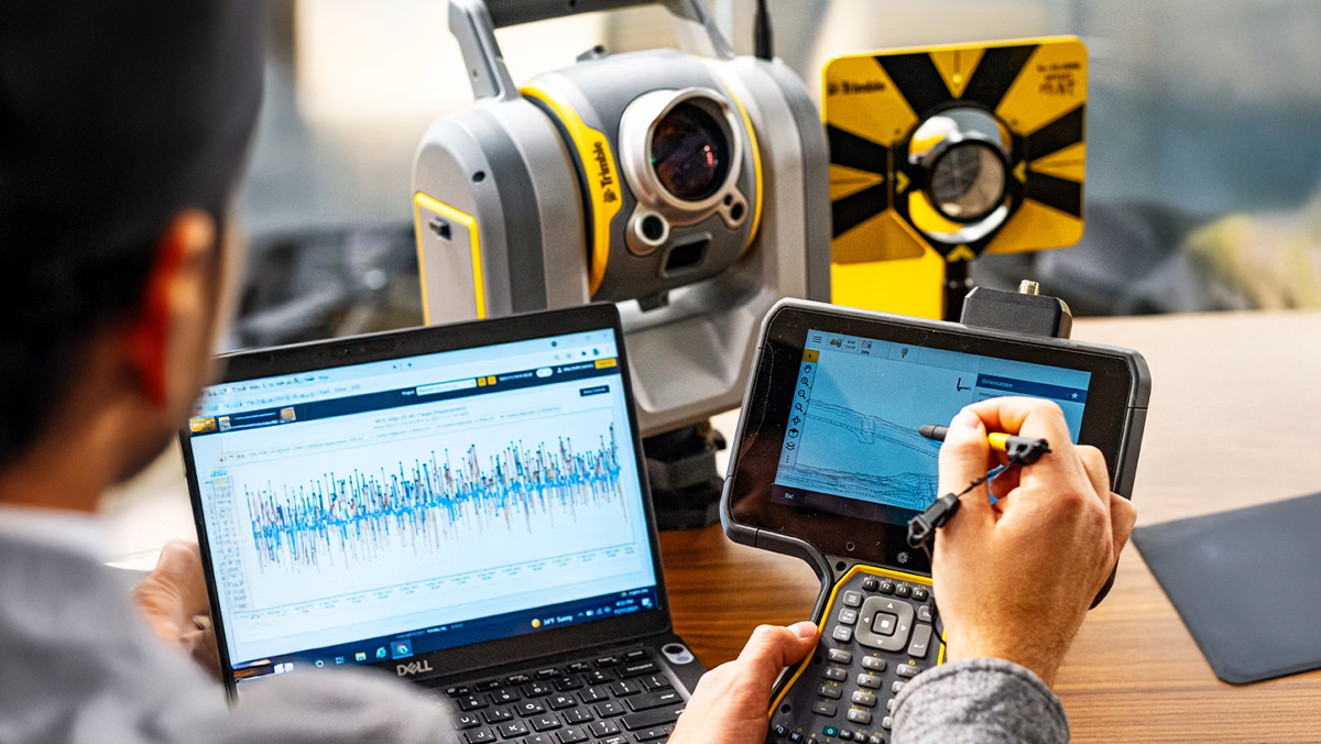 man collecting information with data collector and total station